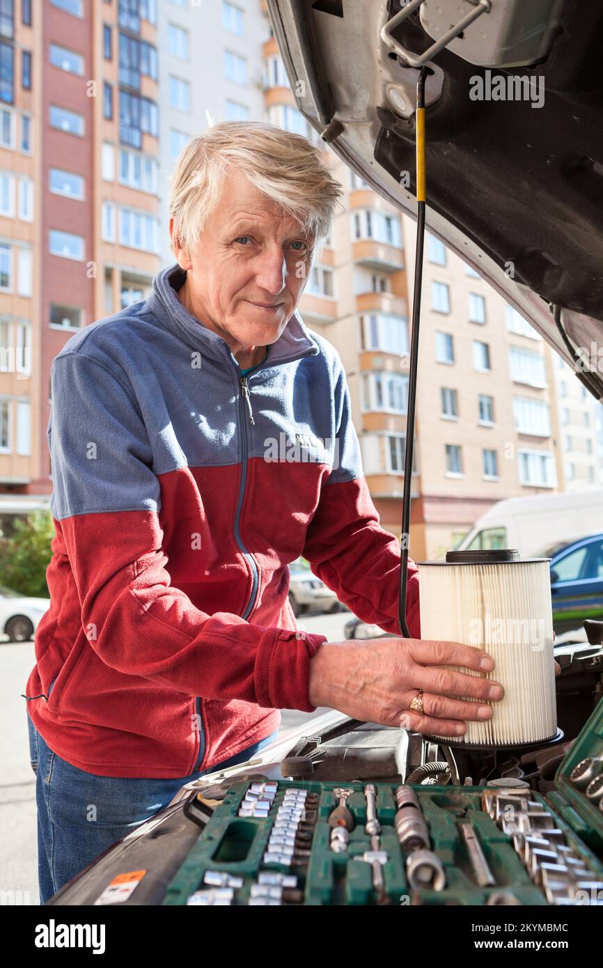 Replacing the air filter in the car, a man with a new air vent in his
