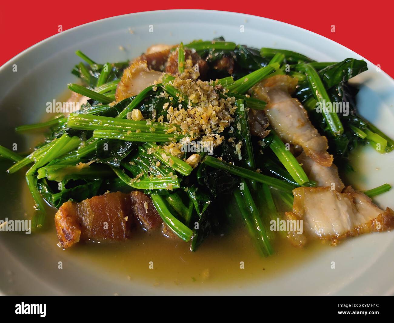 Isolated Stir Fried Spinach with crispy pork Stock Photo