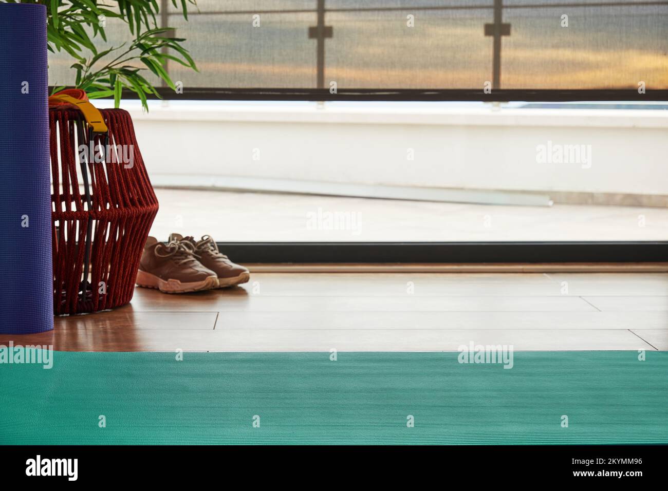 Aerobic center room with exercise mat, sneakers and wide windows
