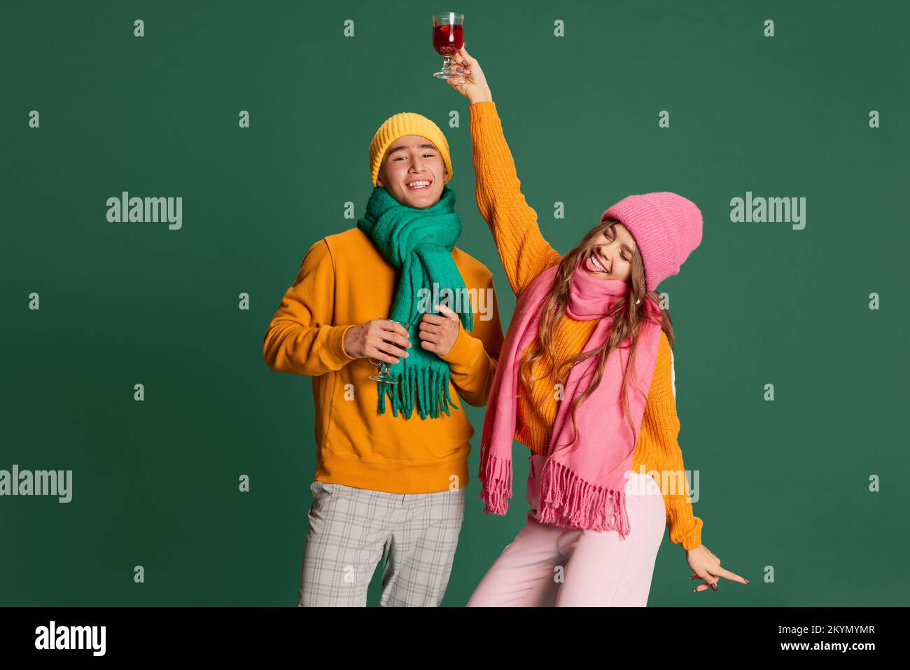 Portrait of young man and woman in bright knitted hat and scarf posing ...