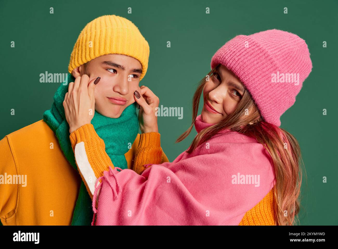 Portrait of young man and woman, lovely couple in bright knitted hat ...