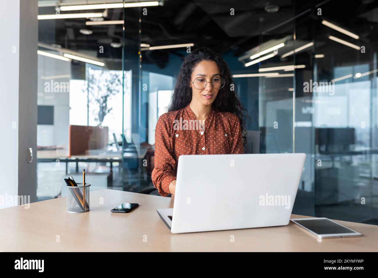Cheerful and successful indian woman programmer at work inside modern ...