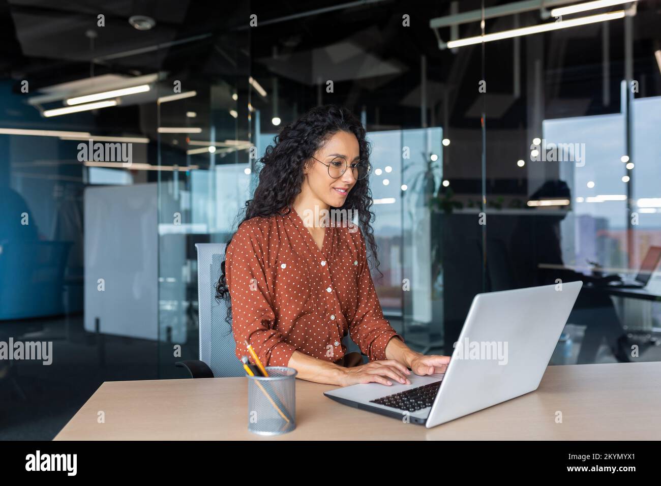 Cheerful and successful indian woman programmer at work inside modern ...