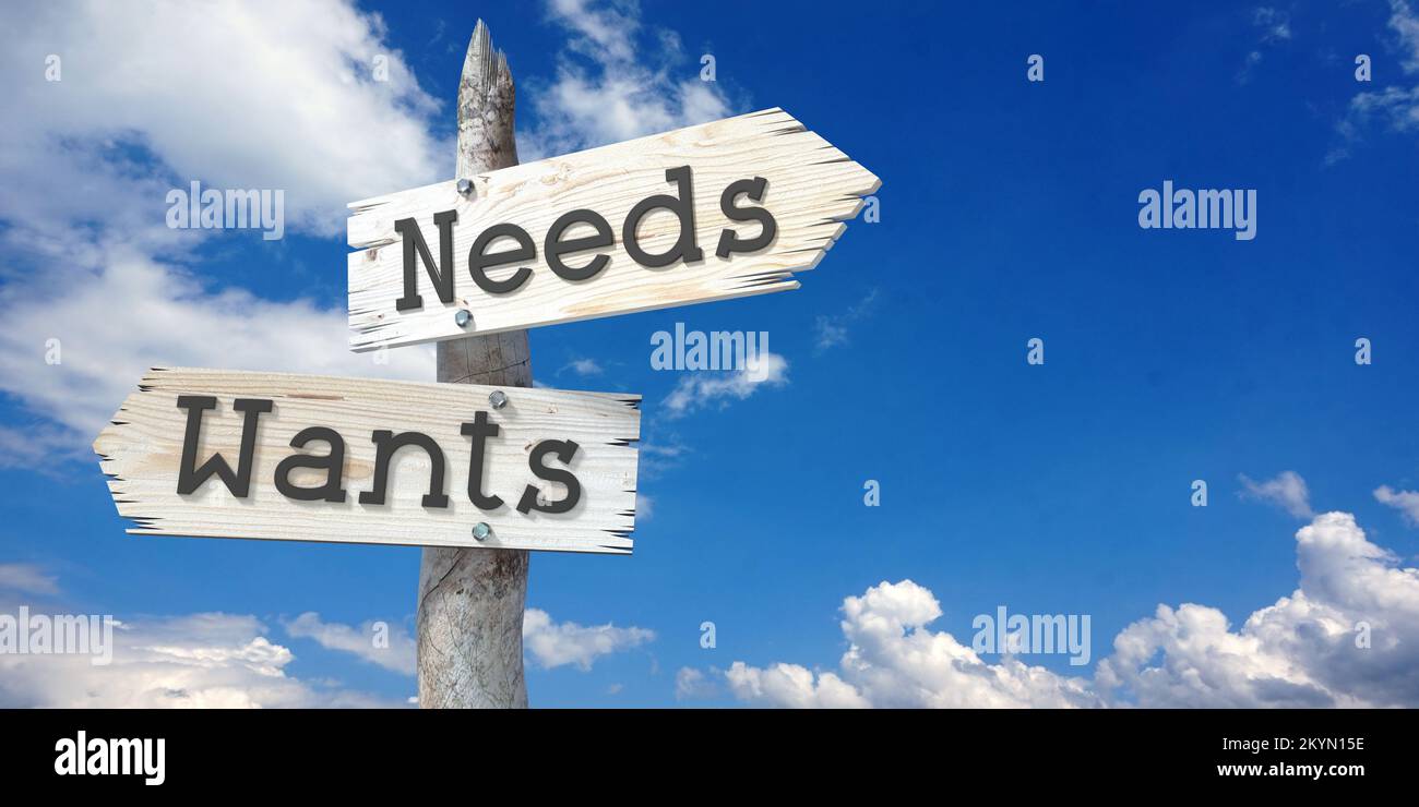 Needs and wants - wooden signpost with two arrows Stock Photo - Alamy