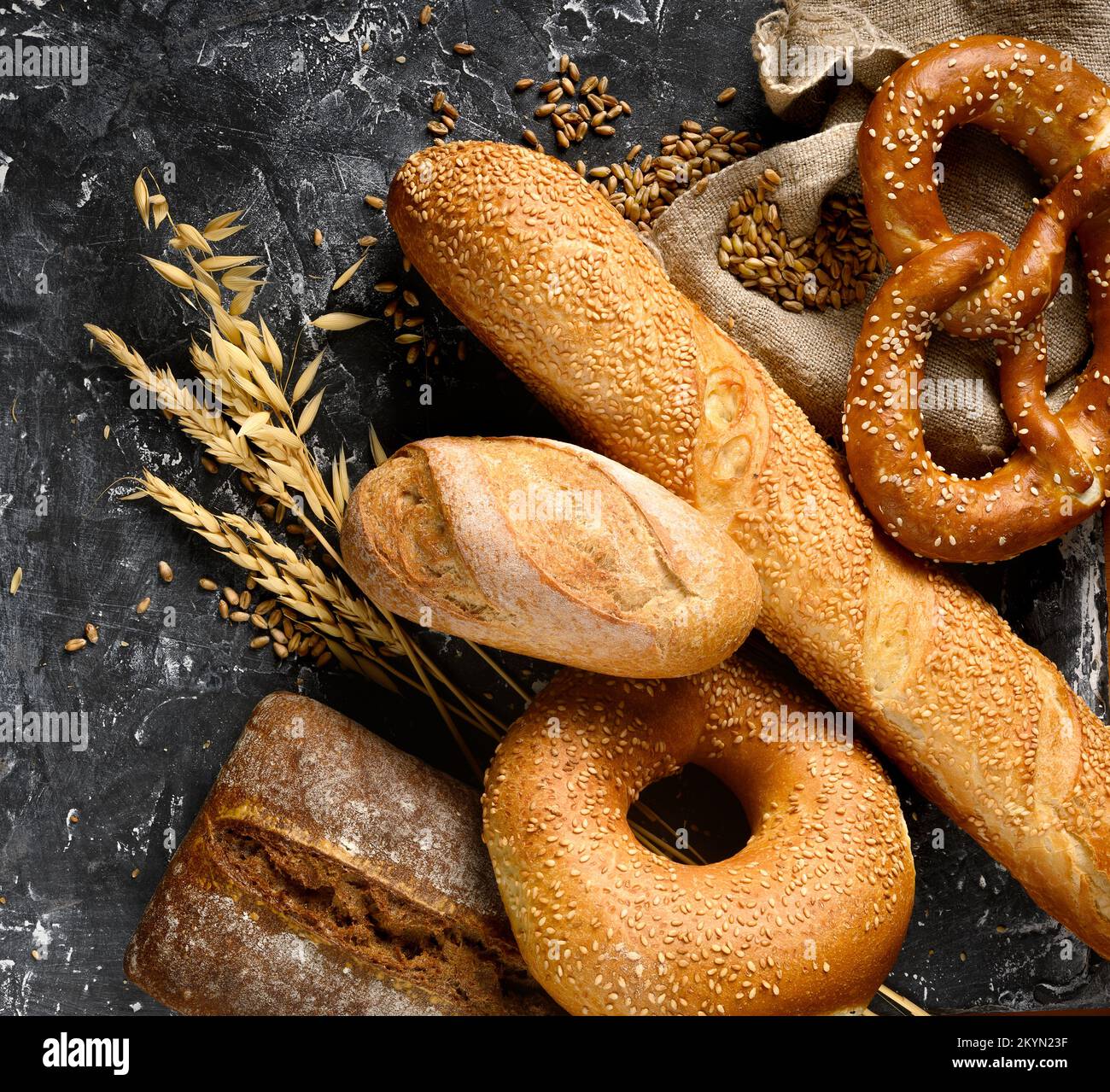 Baked bread assortment on black board background. Stock Photo