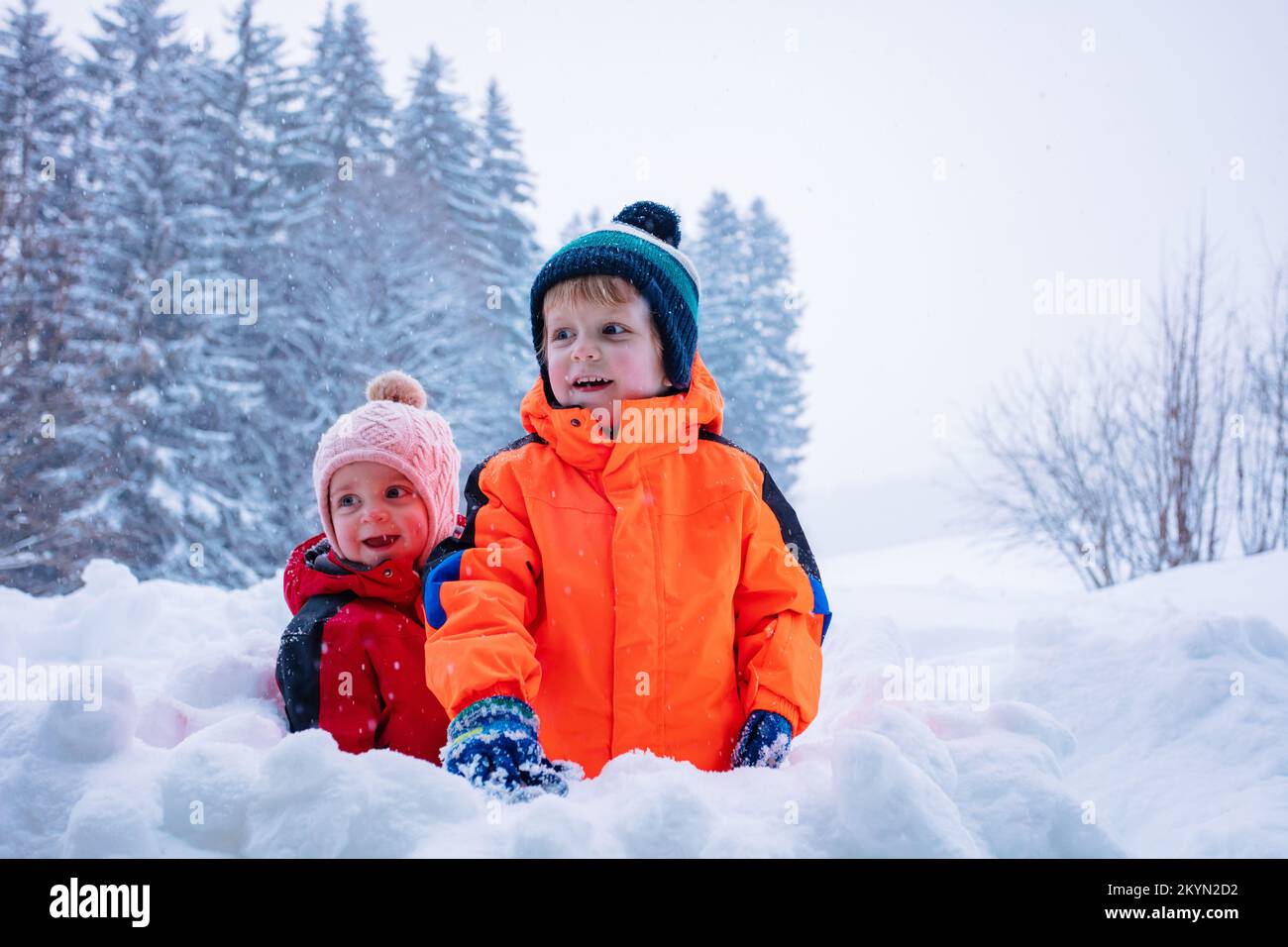 Boy with sister play snowball in the snow fortress Stock Photo - Alamy