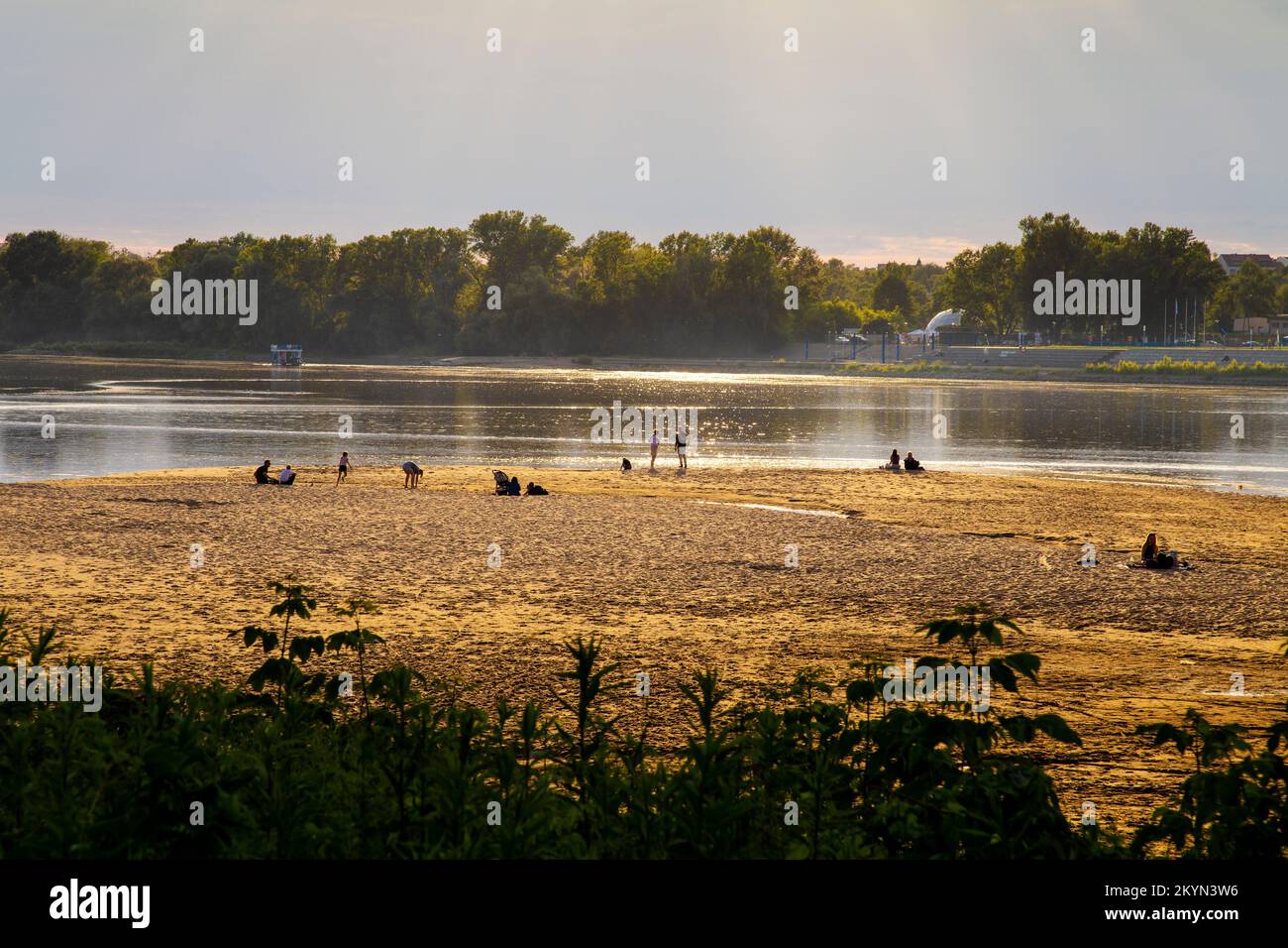 People enjoying a sunny day at the Vistula river riverbank city beach, Torun, Poland Stock Photo