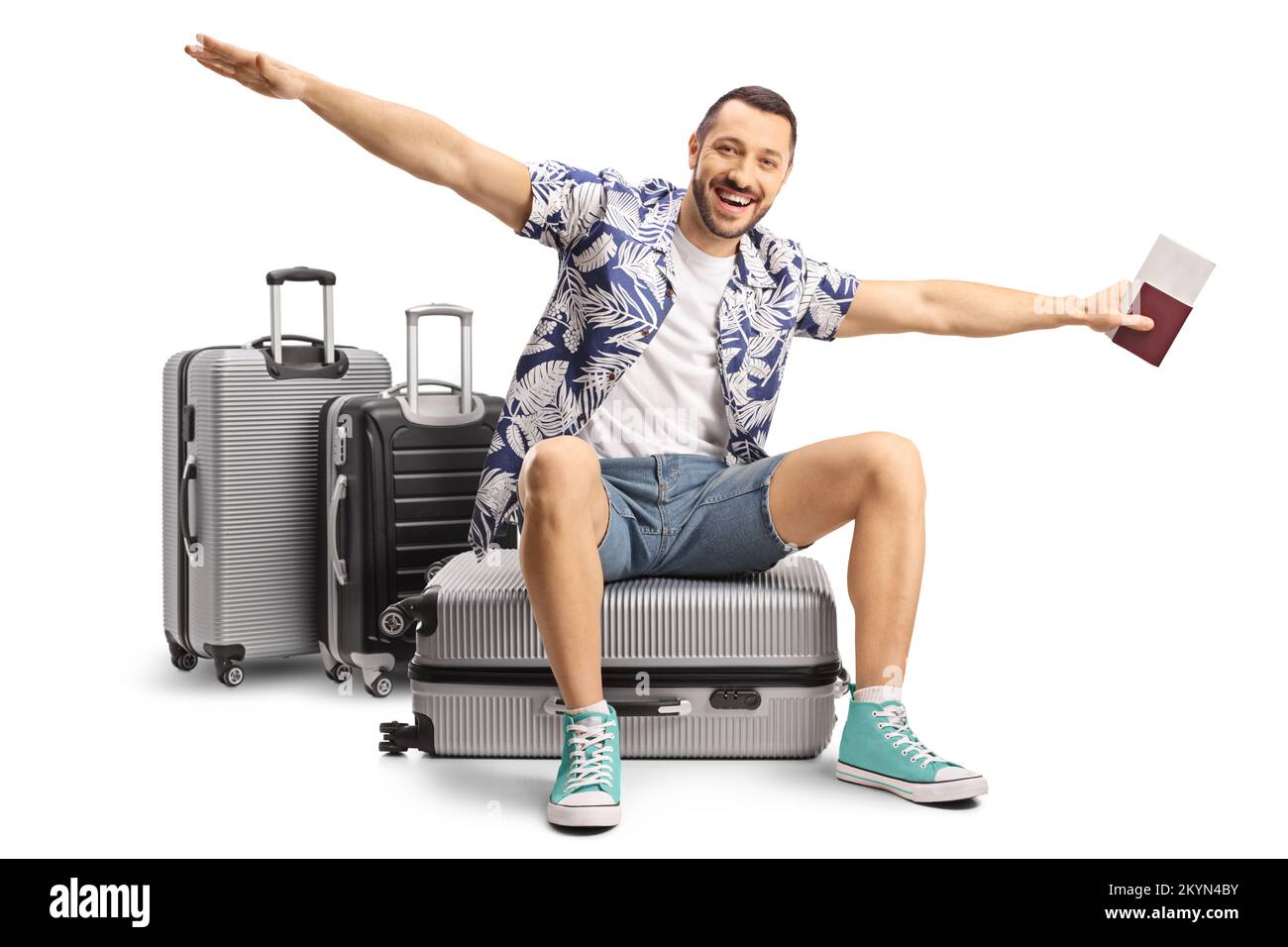 Male tourist sitting on a suitcase and spreading arms to fly isolated on white background Stock Photo