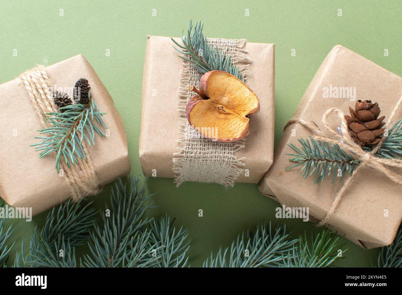 Three Christmas gifts wrapped in kraft paper and painted with natural ...