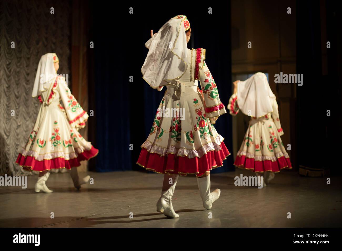 Girls dancing in folk costumes. On stage. Folk dance. Large dresses. Stock Photo