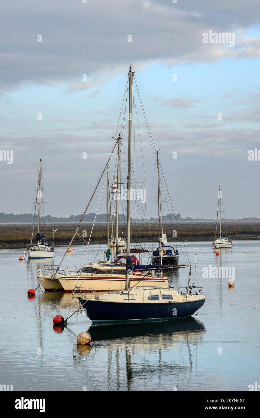 Boats reflected in the calm waters of the harbour at Wells-next-the-Sea in Norfolk on a still December day Stock Photo