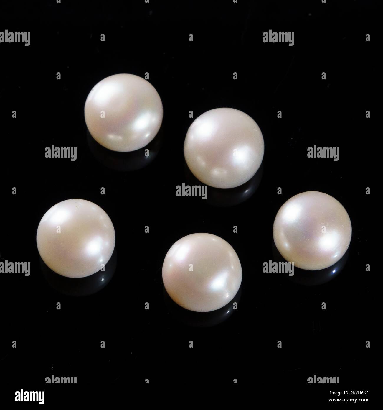 Natural pearls on a black background. White round pearls Stock Photo
