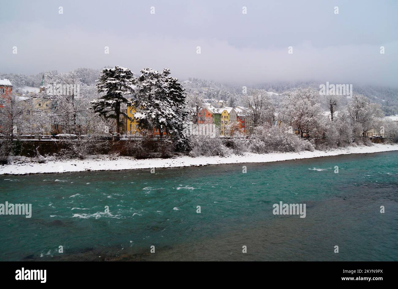 scenic wintery Innsbruck with its colorful old houses on the turquoise river Inn in the foggy snowy Austrian Alps (Austria) Stock Photo