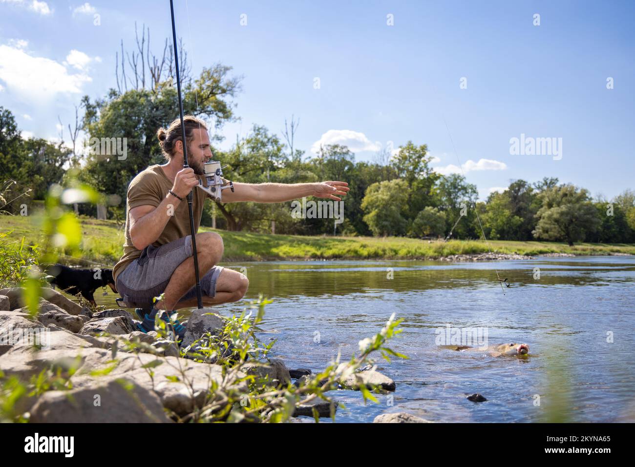 Hobby fisher caught a fish in a river Stock Photo