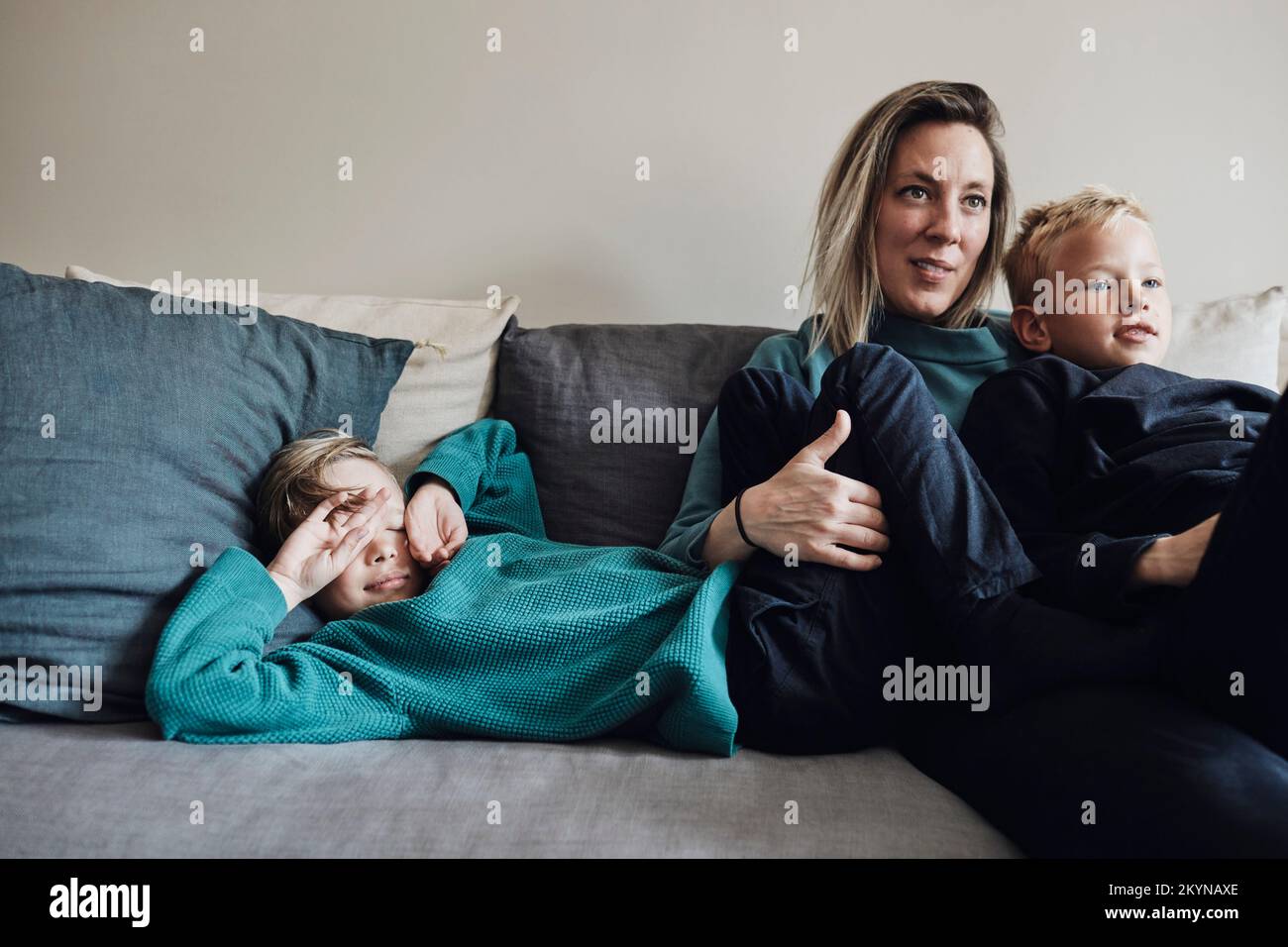 Woman spending leisure time with sons on sofa at home Stock Photo