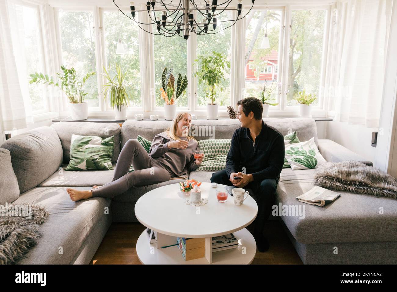 Happy couple having juice while spending leisure time at home Stock Photo