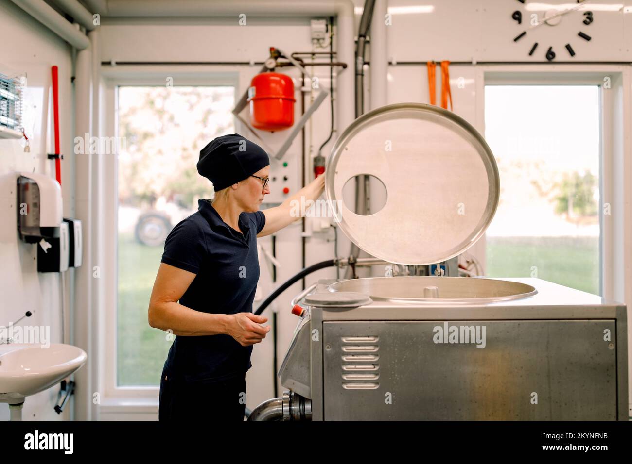 Farmer examining machine at dairy factory Stock Photo Alamy