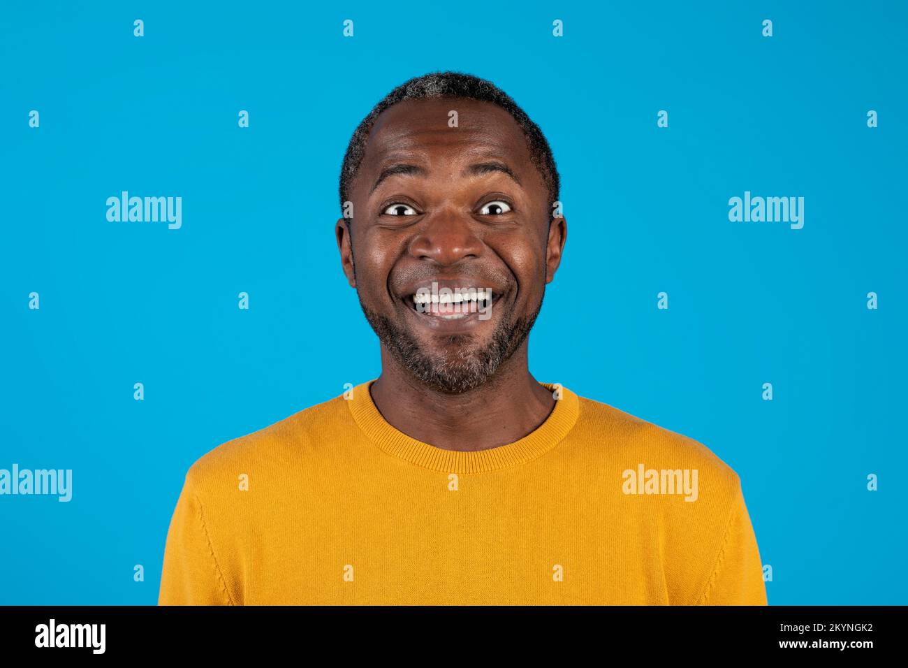 Closeup of excited black man smiling isolated on blue Stock Photo