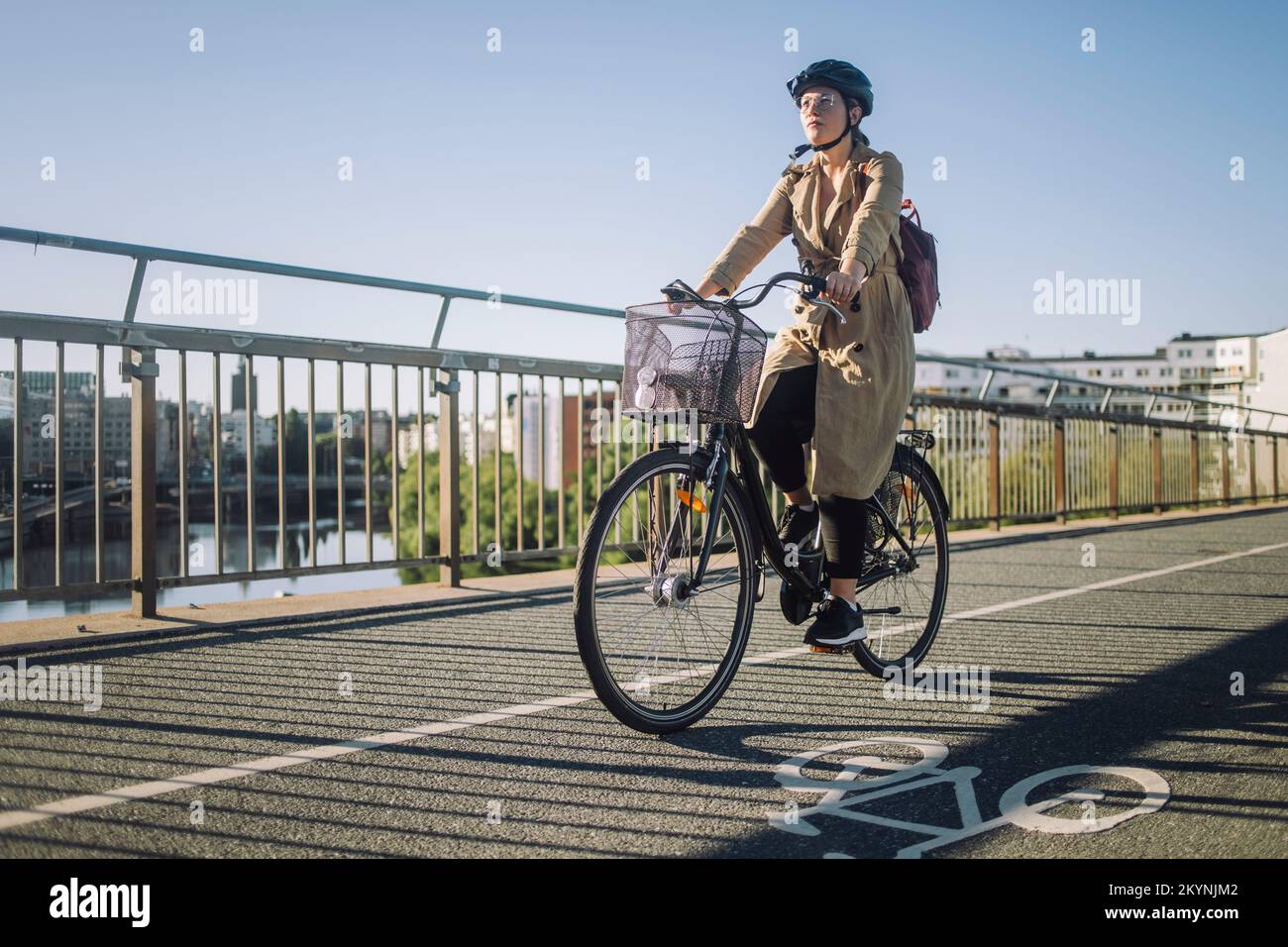 Young businesswoman riding cycle on bicycle lane while commuting to work Stock Photo