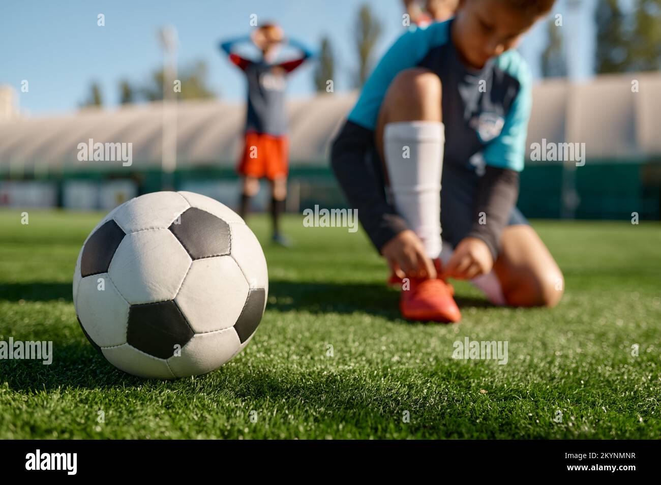 Soccer ball on grass and children football team training Stock Photo