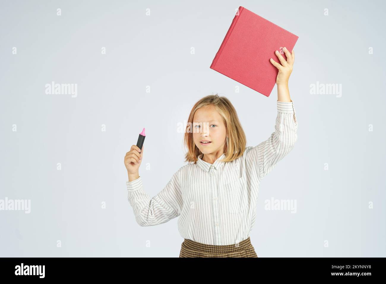 Portrait of a teenage girl who holds a book above her head and a marker ...