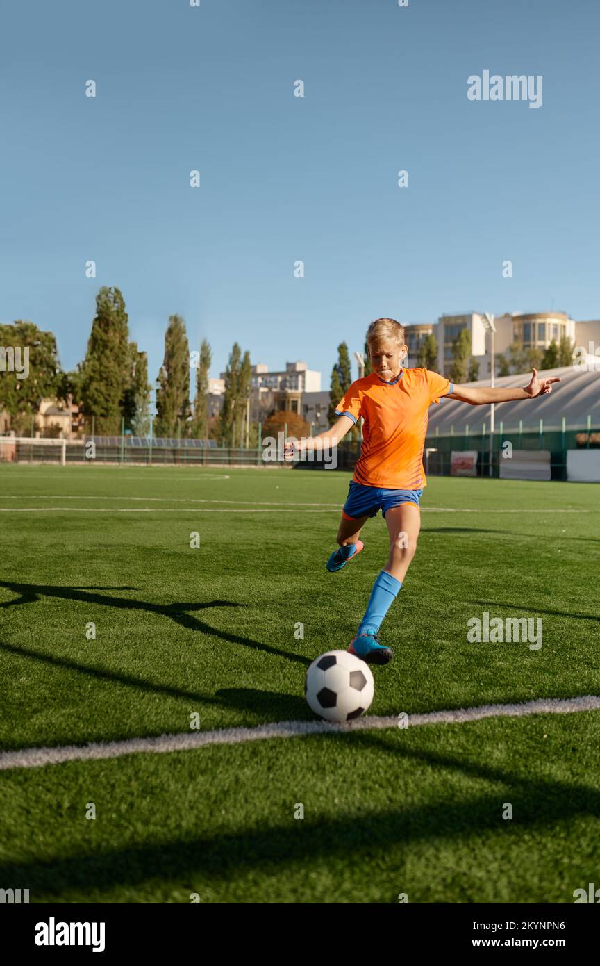 Young soccer goalie starting game kicking ball from white goal line