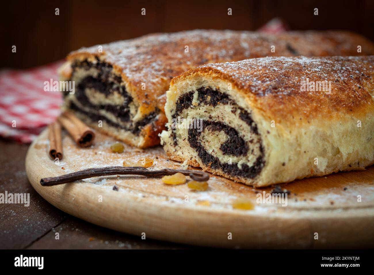 Homemade poppy seed strudel on wooden board. Cut across. Sweet Poppy
