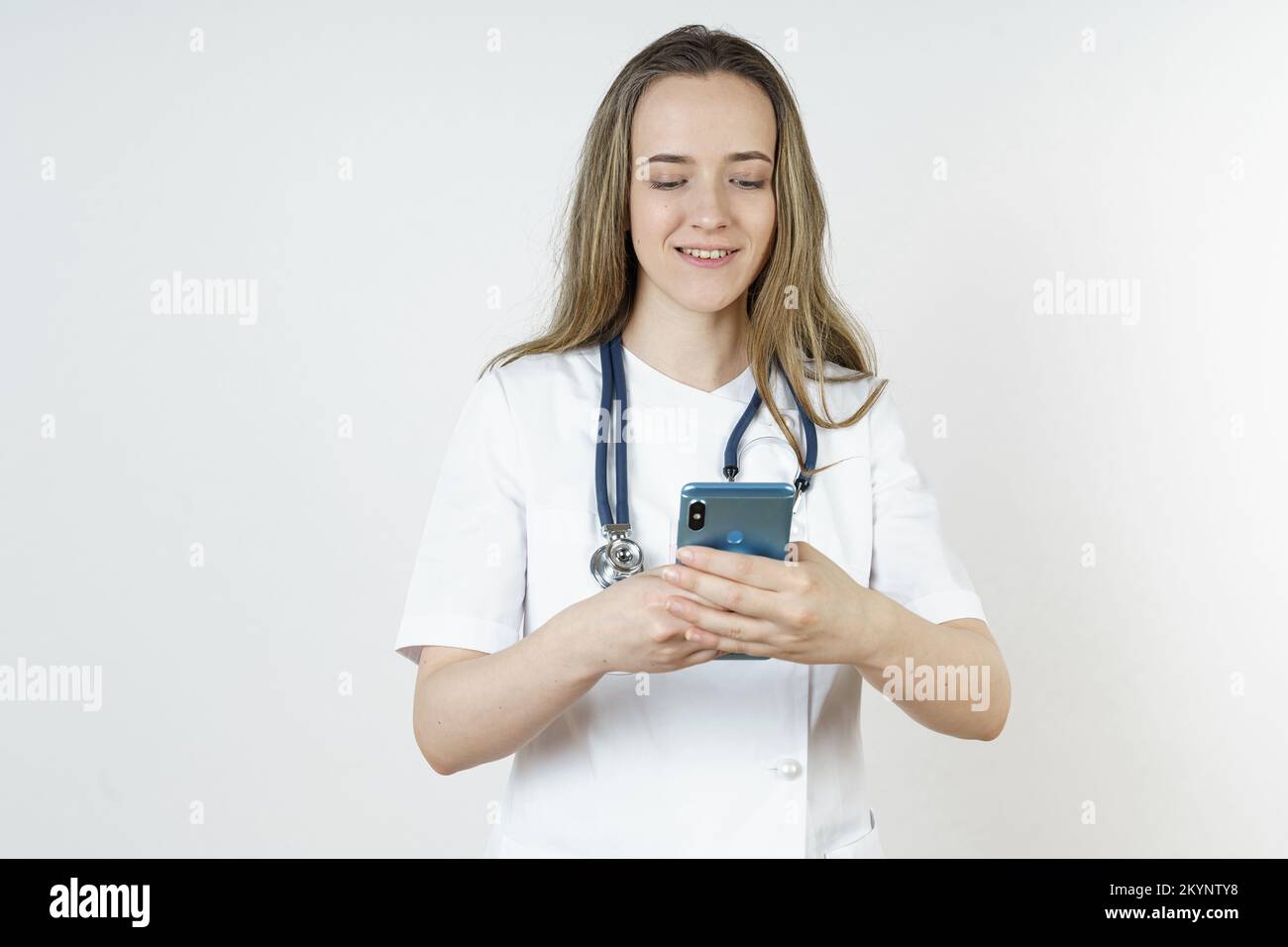 Medicine and health concept. Young woman doctor message in mobile phone. Isolated on white background. Stock Photo
