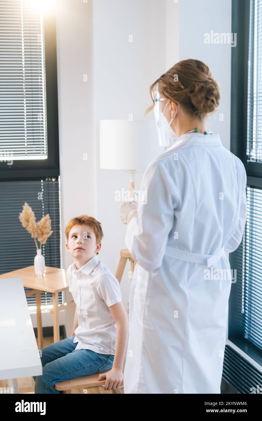Vertical shot of unrecognizable female doctor in latex gloves preparing ...