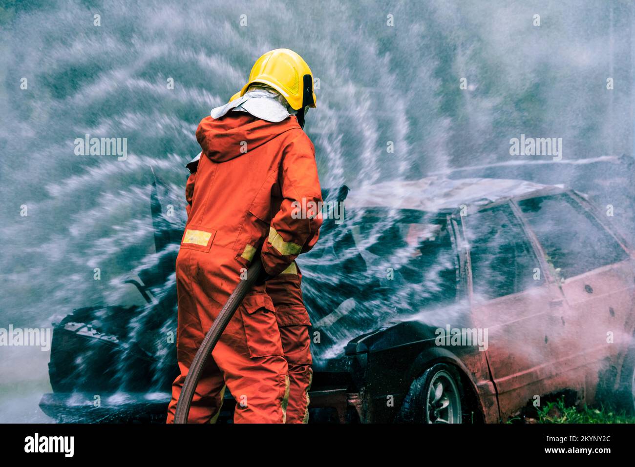 Firefighter Rescue training to stop burning flame, Fireman wear hard hat and safety uniform suit for protection burn using hose with chemical water fo Stock Photo