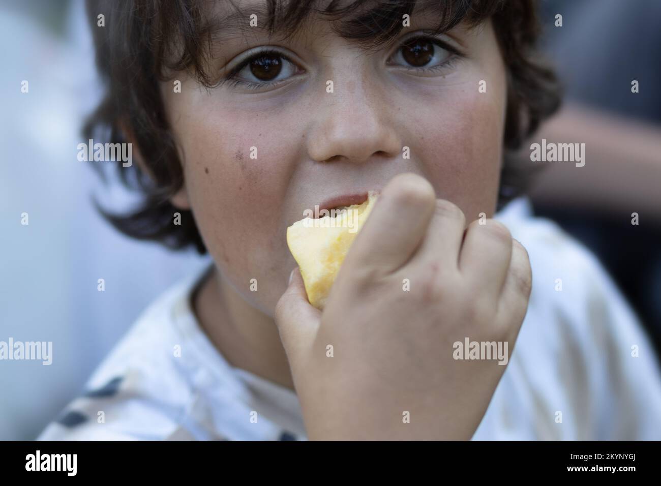 Brown-eyed cute boy eating an apple Stock Photo