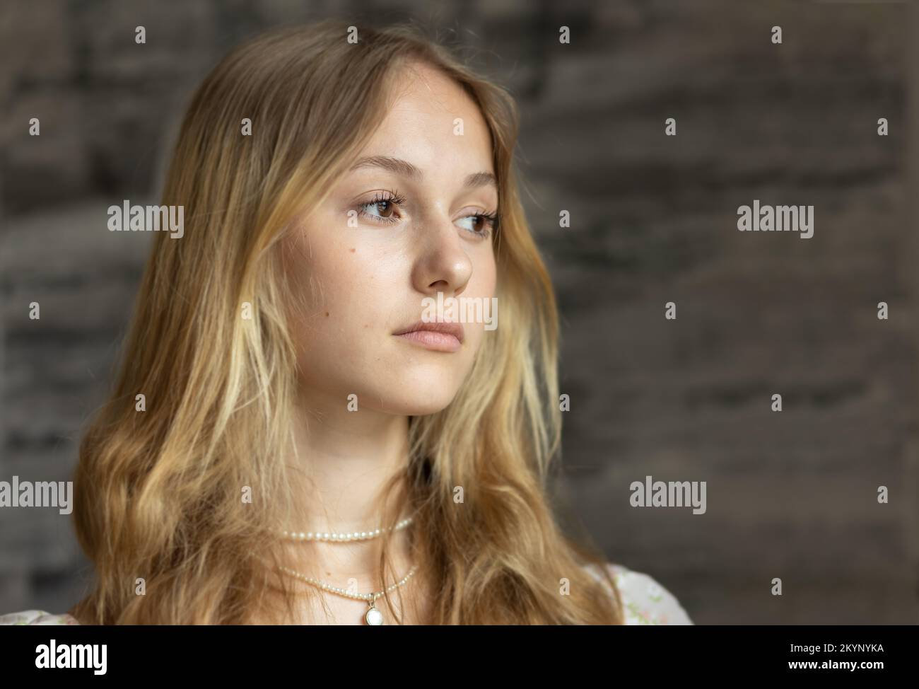 Studio portrait of a long-haired young blonde woman on a dark background Stock Photo