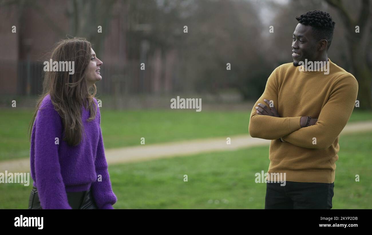 Young woman flirting black man punching and teasing him. Interracial couple together Stock Photo