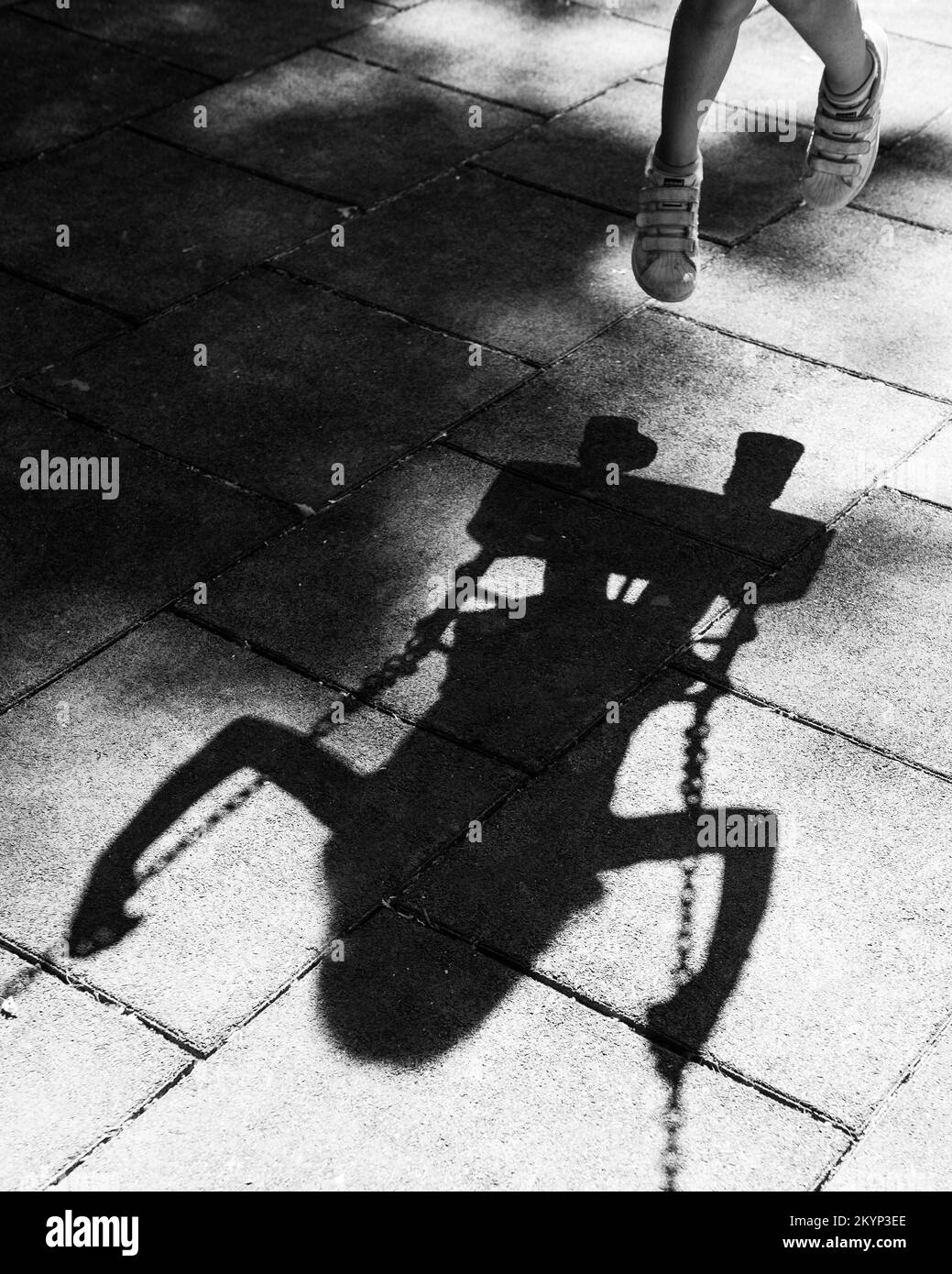 Silhouette and shadow of child swings in a toddler swing in a playground. Children play outdoor Stock Photo
