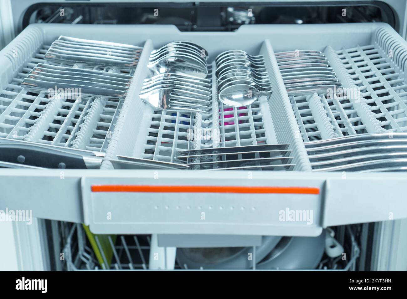 Upper pullout shelf of dishwasher with clean sparkle cutlery in