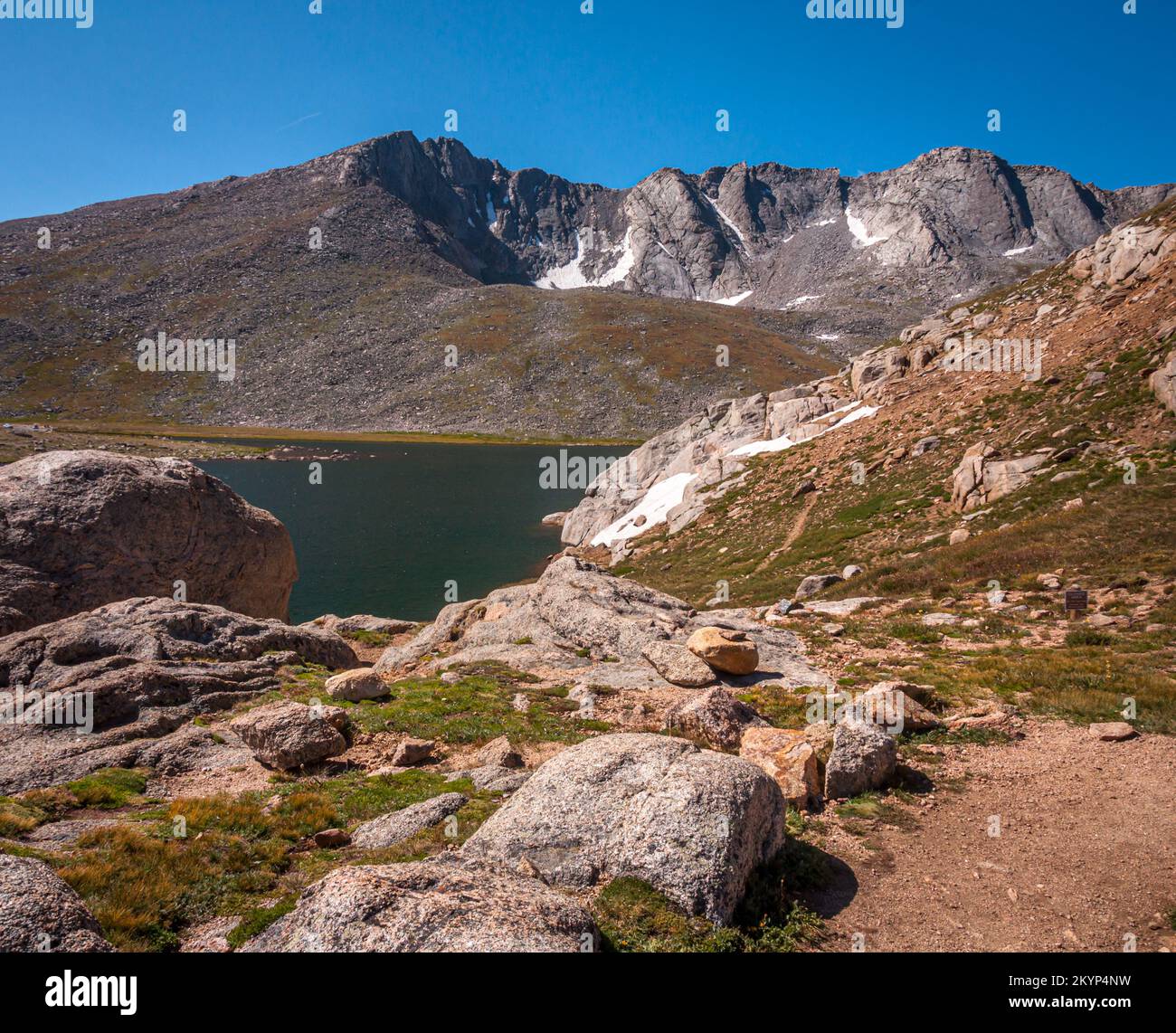 The rocky rugged shoreline of Summit Lake on Mount Evans, Colorado beneath a summer sky. Stock Photo