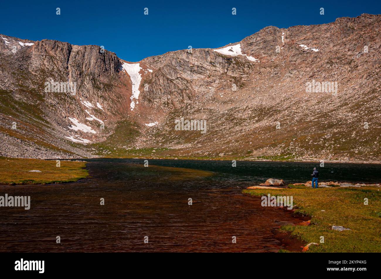 A beautiful blue sky over majestic mountains at Summit Lake on Mount Evans, Colorado being enjoyed by a photographer. Stock Photo