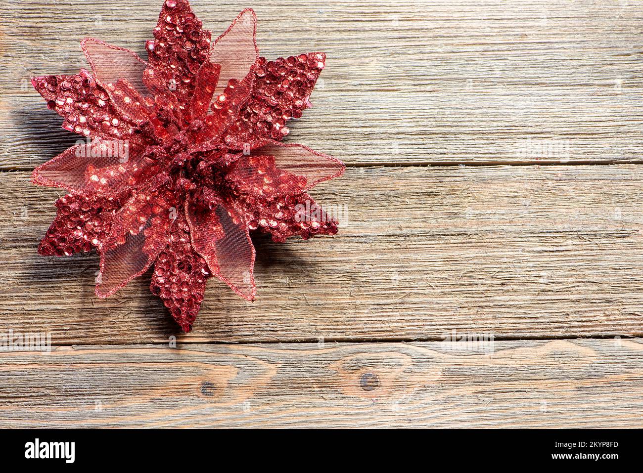 Red Christmas Poinsettia ornament on a wooden background, farmhouse style, no text Stock Photo