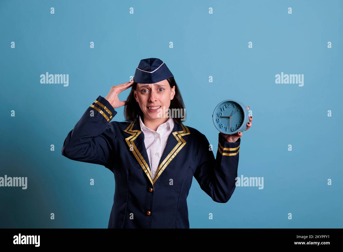 Anxious flight attendant holding retro alarm clock, running late at