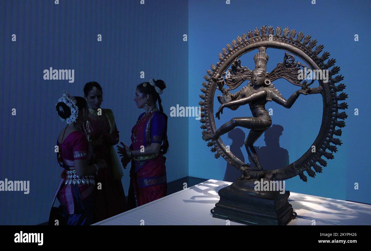 JERUSALEM, ISRAEL - DECEMBER 1: Bharatanatyam dancers chat next to ancient bronze sculpture of Shiva as the Lord of Dance (Nataraja) during the launch event of an exhibit titled “Body of Faith” to mark the 75th anniversary of India’s independence at the Israel Museum on December 1, 2022 in Jerusalem, Israel. The display features 14 large-scale  sculptures of deities, created between the fourth and 13th centuries, 8 of them for the first time outside of the National Museum of India. Credit: Eddie Gerald/Alamy Live News Stock Photo