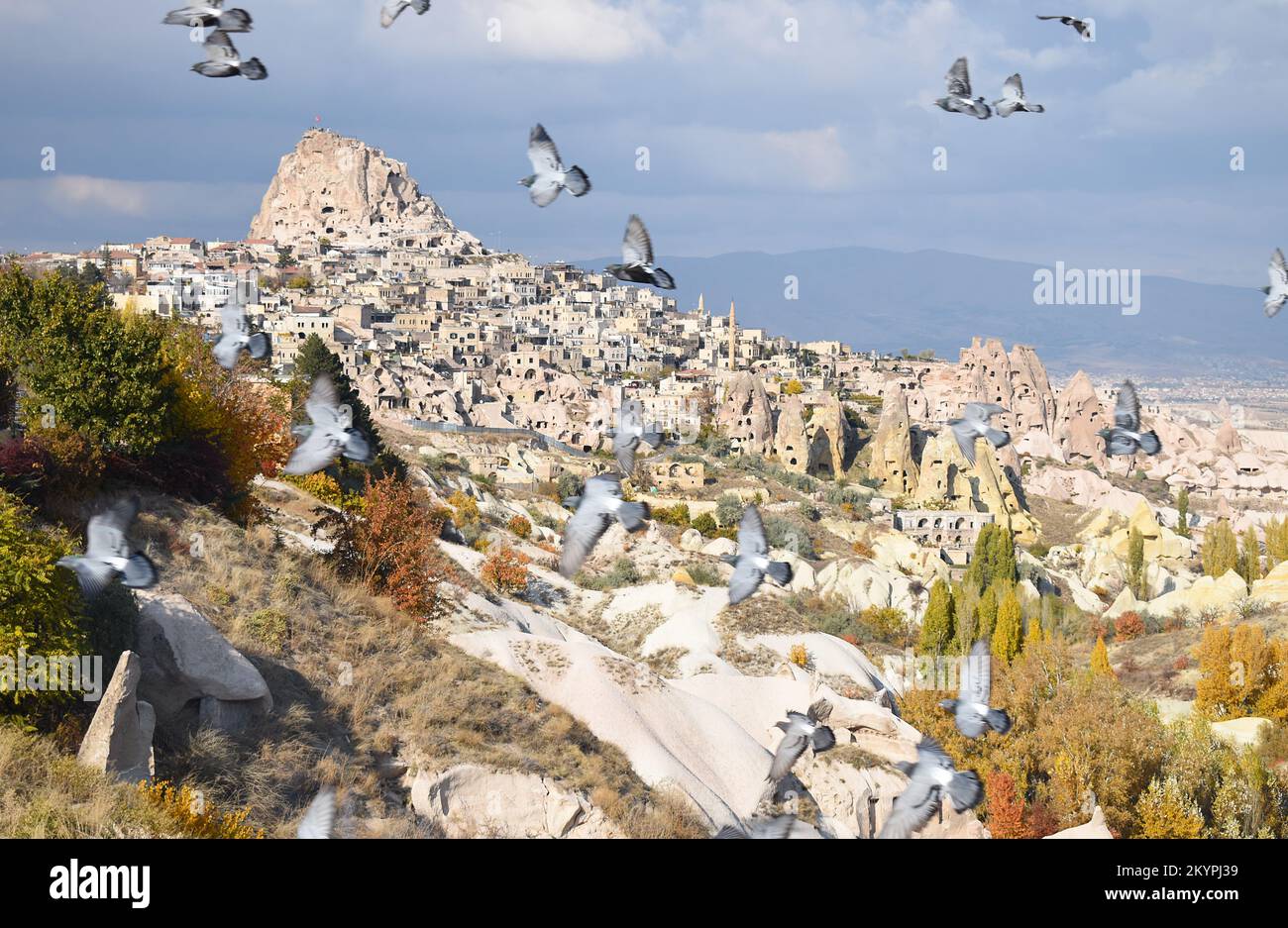 View of Uçhisar castle and cave city carved into the fairy chimneys in Cappadocia, Turkey, taken from Pigeon Valley on a bright cloudy Autumn day. Stock Photo