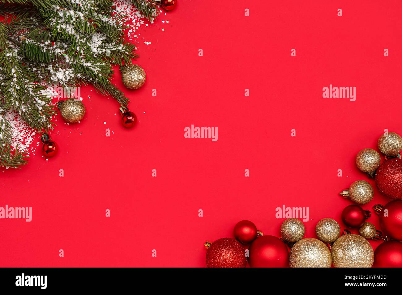 Frame made of Christmas balls, fir branches and snow on red background ...