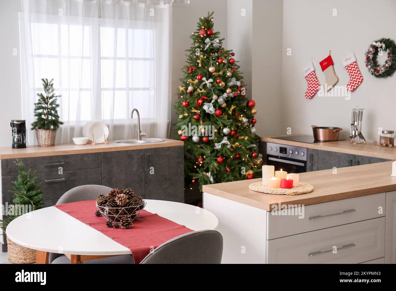 Interior of kitchen with Christmas trees, counters and dining table ...