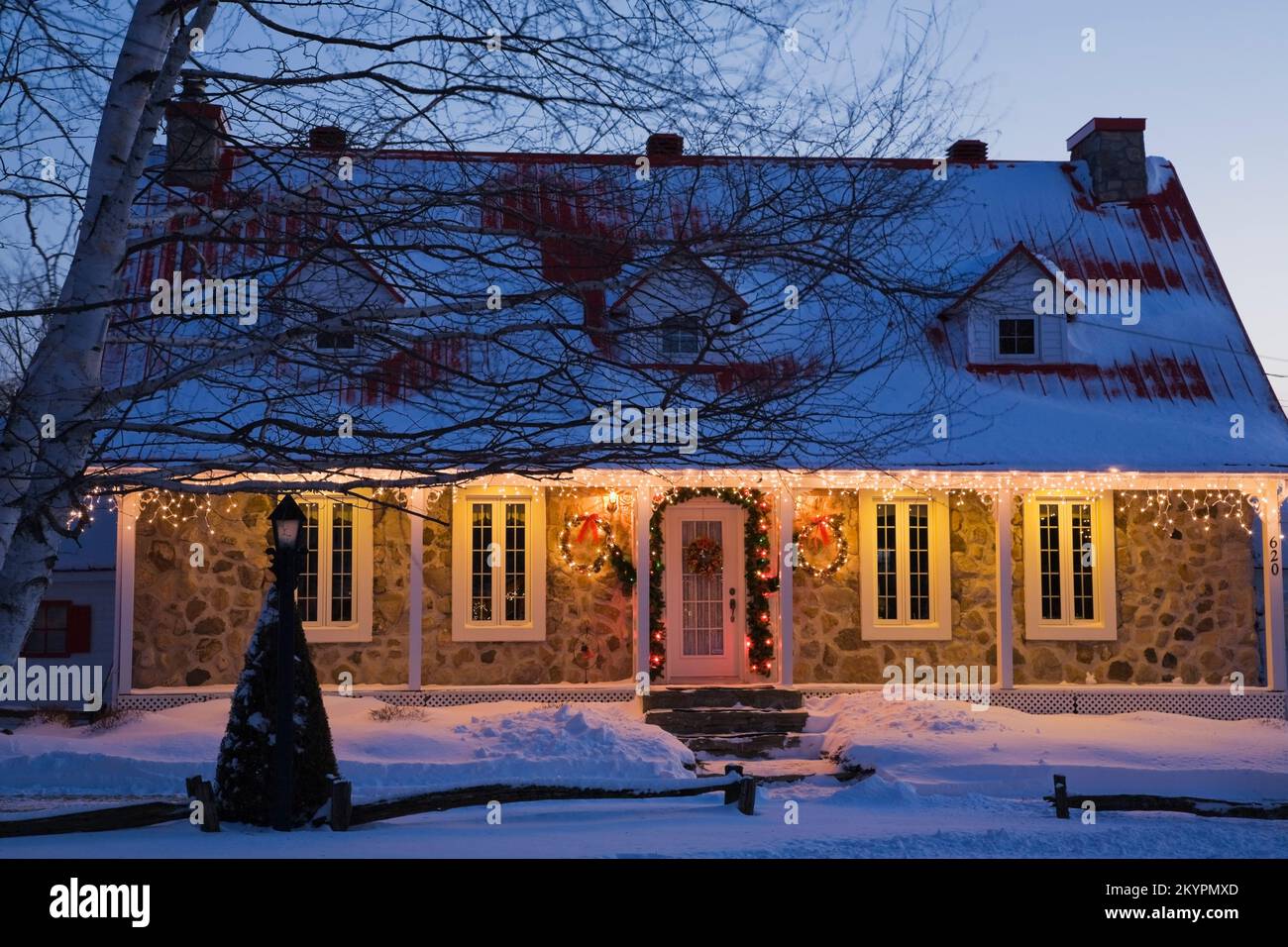 Illuminated two storied fieldstone Canadiana style home decorated with