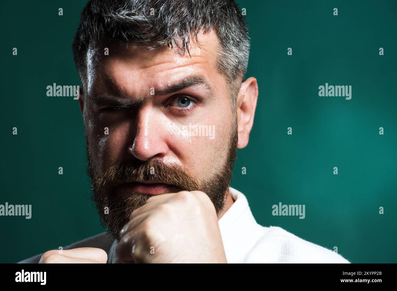 Karate fighter in kimono ready to fight. Combat sport. Martial arts master training in gym. Closeup. Stock Photo