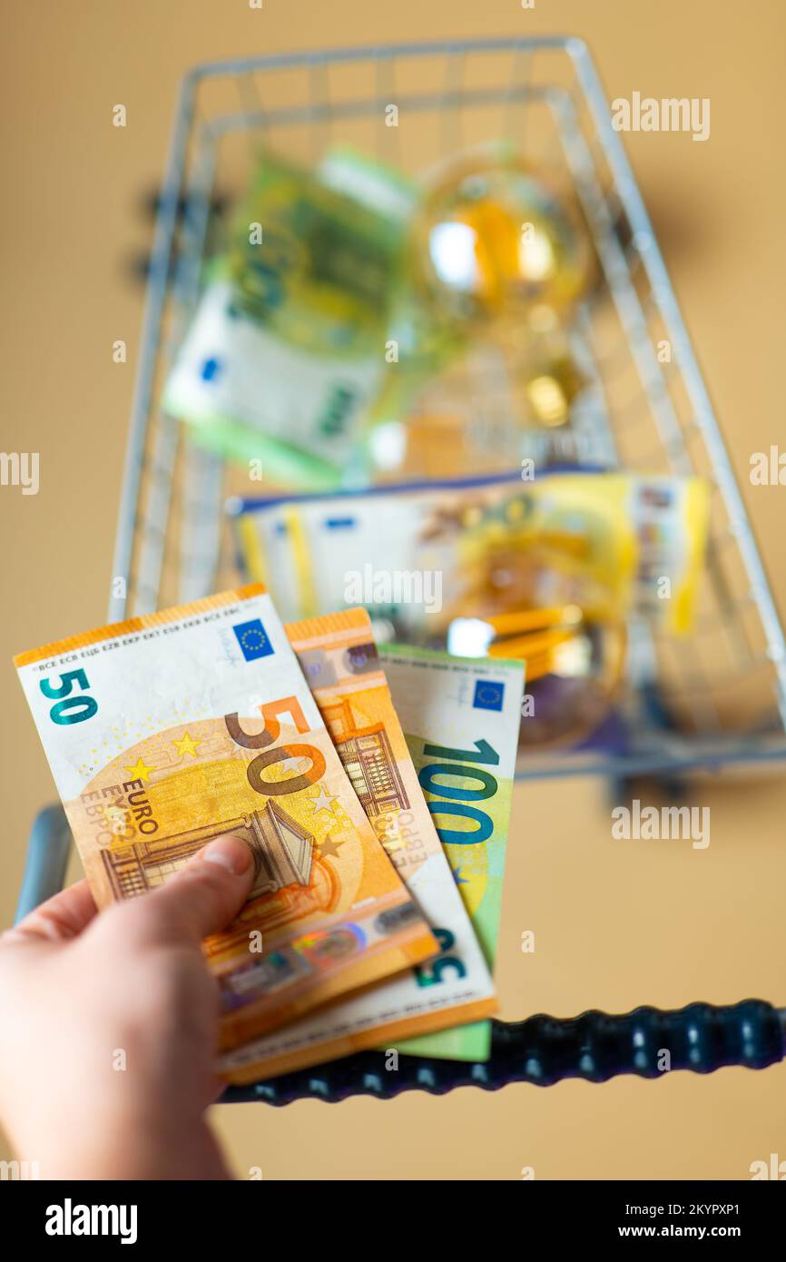 Payment of electricity bills.Hand puts euro money in a supermarket trolley with Light bulbs set