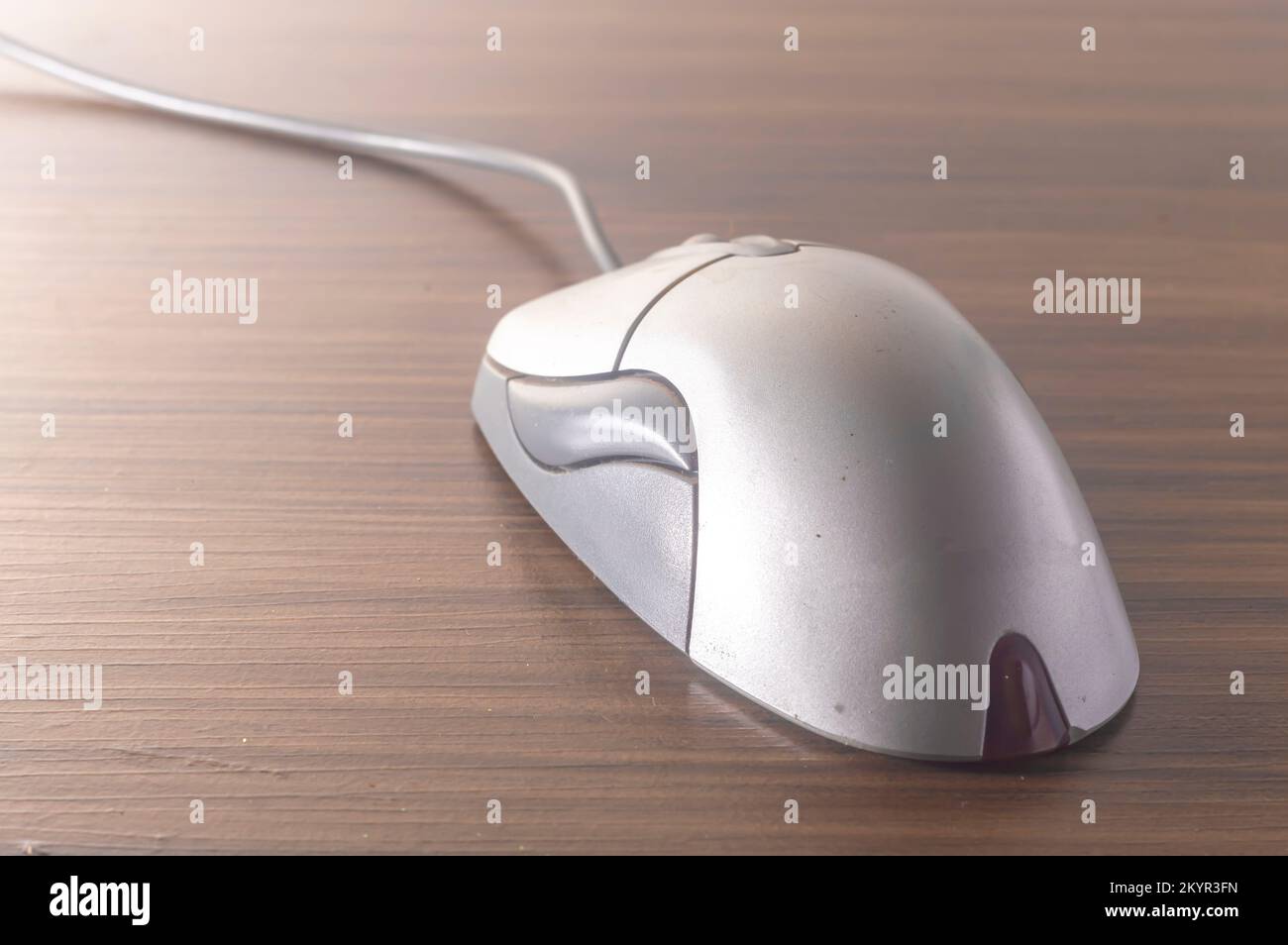 Modern computer mouse with wooden background and copy space. Stock Photo