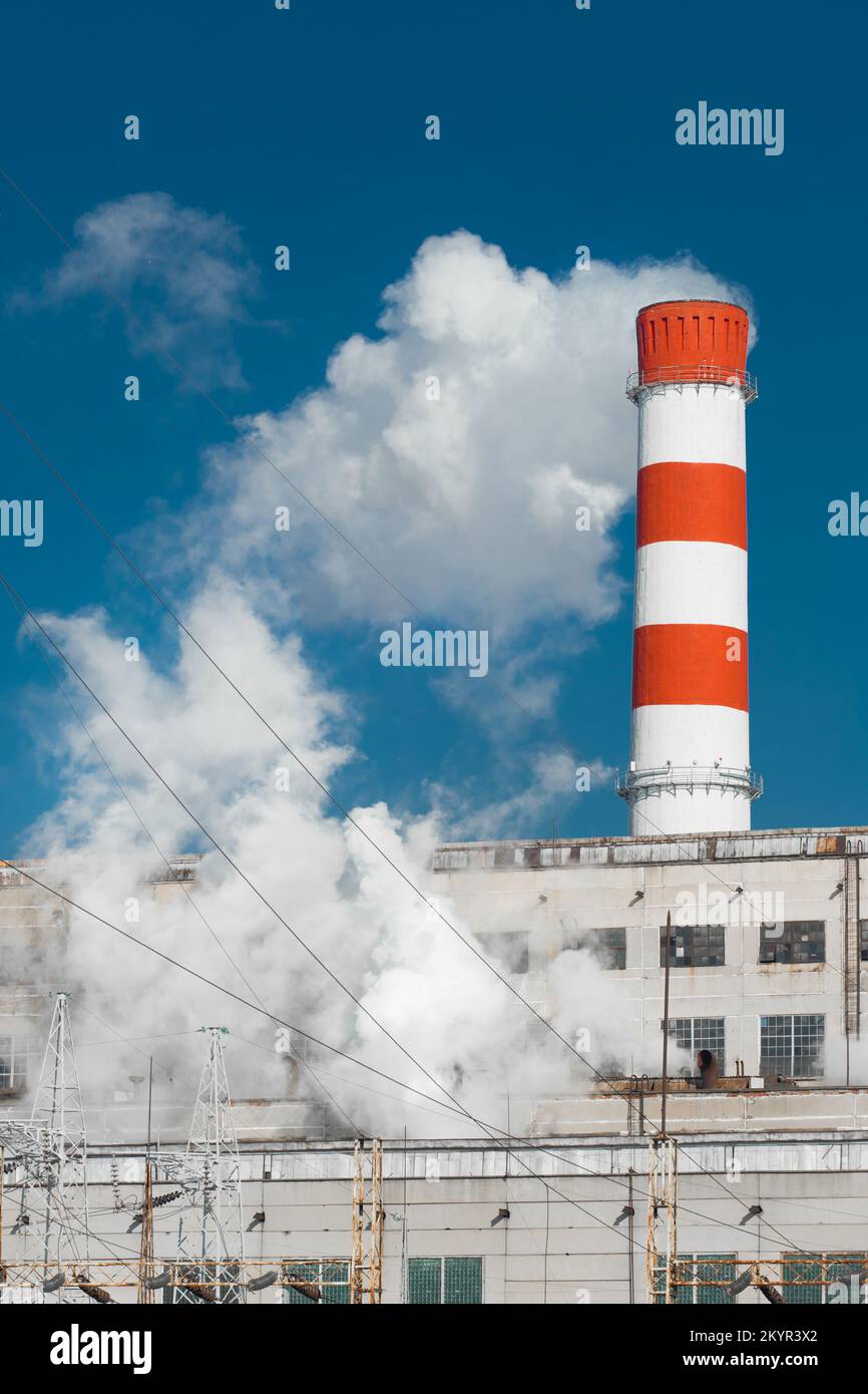 Pollution of the environment, ecology and air. Withdrawal of combustion products of soot, smoke and gases from the pipe of an industrial plant into th Stock Photo