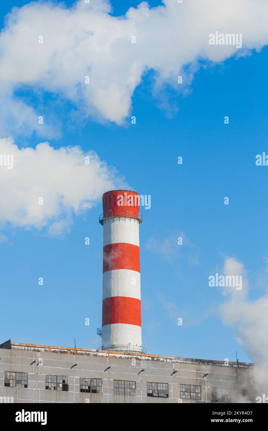 Pollution of the environment, ecology and air. Withdrawal of combustion products of soot, smoke and gases from the pipe of an industrial plant into th Stock Photo