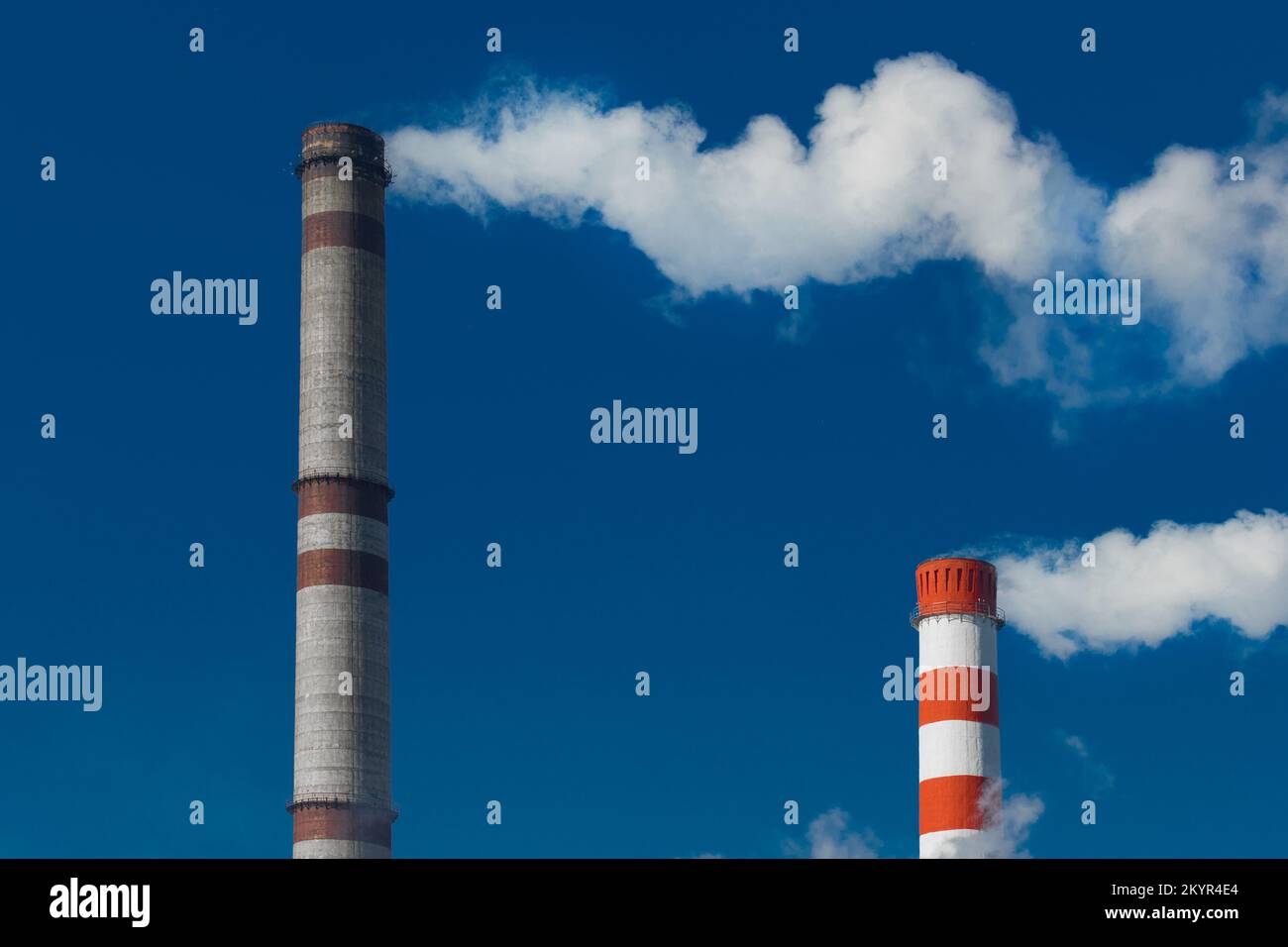 Pollution of the environment, ecology and air. Withdrawal of combustion products of soot, smoke and gases from the pipe of an industrial plant into th Stock Photo